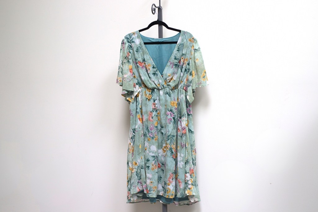 Florence Flutter Sleeve Dress in Sage Floral Print with short flutter sleeves and a V-neckline, displayed on a black hanger against a clean white background.